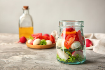 Delicious vegetable salad in jar on table