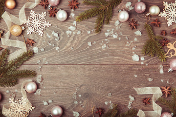 Obraz na płótnie Canvas Christmas holiday rustic composition. Festive creative gold vintage pattern, spruce branches, xmas tree, xmas golden decor holiday ball with ribbon on wooden brown background. Flat lay, top view