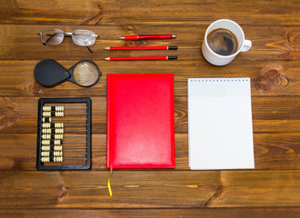 note book and pencil with cup coffee on wooden table