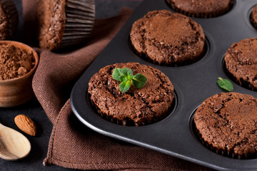 Chocolate muffins, brownies with nuts and chocolate on a black background