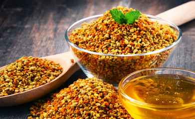 Bowls with bee pollen and honey on kitchen table