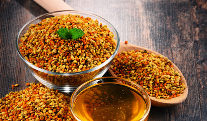 Bowls with bee pollen and honey on kitchen table