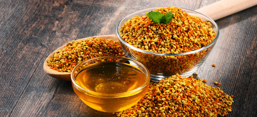 Bowls with bee pollen and honey on kitchen table
