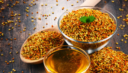 Bowls with bee pollen and honey on kitchen table