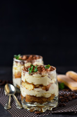 Classic tiramisu in a glass jar on the background chermon