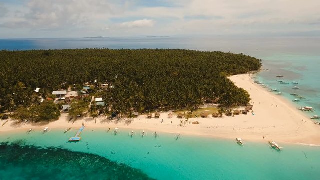 Aerial view of beautiful tropical island Daco with white sand beach. View of a nice tropical beach from the air. Beautiful sky, sea, resort. Seascape: Ocean and beautiful beach paradise. Philippines