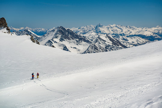 group of people exploring glacier or snowy land walking with alpine ski. Europe Alps Mont Blanc massif mount. Winter sunny day, snow, wide shot.Exploring and travelling