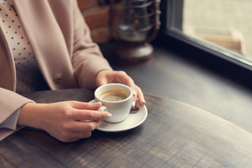woman with white coffee cup on a table