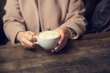 woman with white coffee cup on a table