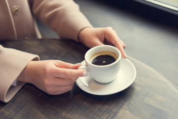 woman with white coffee cup on a table