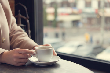 woman with white coffee cup on a table