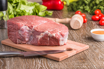 raw beef steak on wooden cutting board
