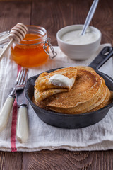 A stack of pancakes with sour cream and honey for Maslenitsa