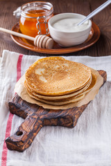 A stack of pancakes with sour cream and honey for Maslenitsa