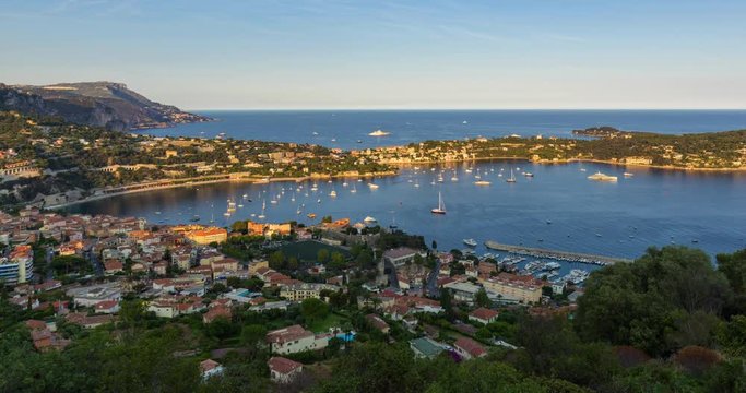 Villefranche-sur-Mer, Saint-Jean-Cap-Ferrat and the Espalmador Bay with yachts and tourist boats in summer (sunset to twilight time-lapse). Cote d'Azur, French Riviera, Alpes Maritimes, PACA, France