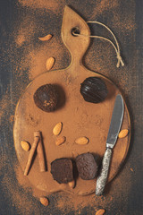 Chocolate cake with cocoa powder on a wooden cutting board.