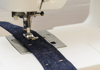 Close-up detail of the sewing machine,blue jeans