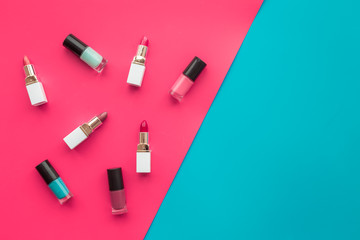 Obraz premium Decorative cosmetics concept. Lipsticks assorted colors and nail polish on red and blue background top view copyspace