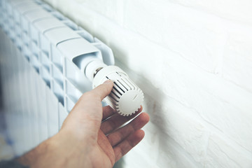 Man Hand Adjusting The Temperature By Thermostat