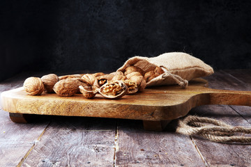 Fototapeta premium Walnut. Walnut kernels and whole walnuts in burlap sack.
