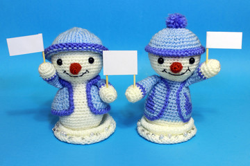 two snowmen with tablets in hands