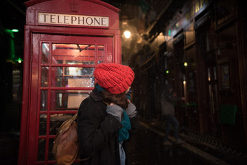 tourist in front of telephone box  on street 