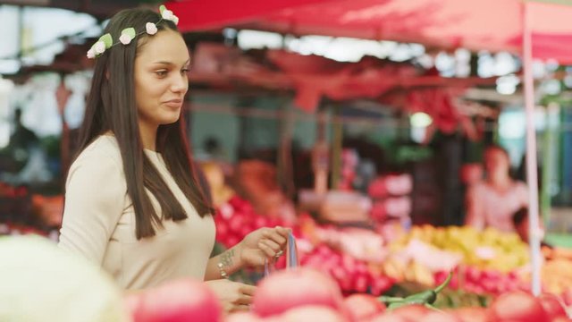 Medium shot of woman paying for fruit at market / Kazanluk, Bulgaria