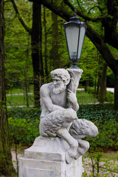 Baroque Statue of a Satyr or Faun holding a Lantern in a Park