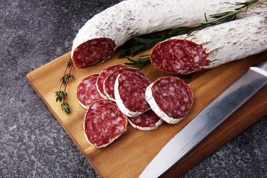 Marble cutting board with sliced salami on it