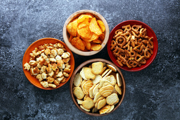 Salty snacks. Pretzels, chips, crackers in wooden bowls