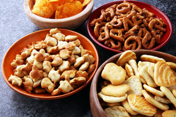 Salty snacks. Pretzels, chips, crackers in wooden bowls
