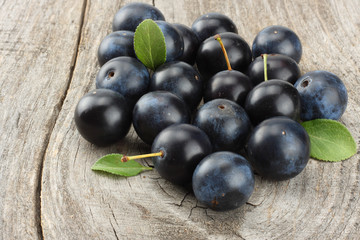 blackthorn berries with green leaf on old wooden table
