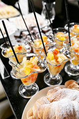 Fresh pastry, crispy morning croissants, hotel breakfast buffet. Dessert fruit cocktail in cups