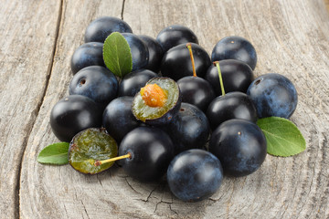 blackthorn berries with green leaf on old wooden table