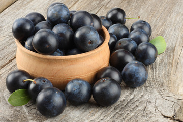 blackthorn berries with green leaf on old wooden table