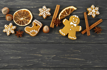 Christmas composition. Cinnamon sticks, anise, gingerbread, hazelnuts and oranges on old wooden table. Top view.