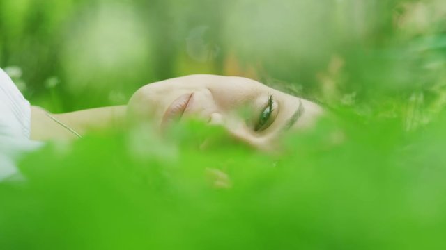 Close up shot of face of woman laying in grass / Kazanluk, Bulgaria