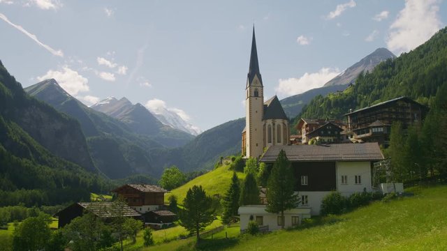 Wide panning shot of houses in green valley / Heiligenblut, Austria