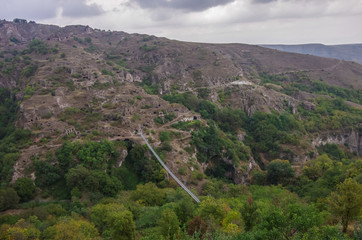 Fototapeta na wymiar Khndzoresk Swinging Bridge. Suspension bridge over the gorge near Goris village. Armenia