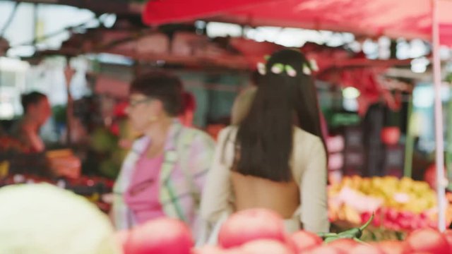 Medium panning shot of woman paying for fruit at market / Kazanluk, Bulgaria