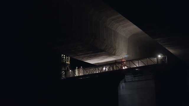 Structural Engineers Working at Night on a Concrete Bridge Inspecting for Cracks and Structural Damage