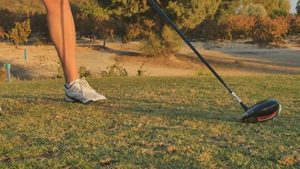 Woman hit the ball with golf club
