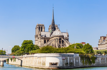 Fototapeta na wymiar Notre Dame de Paris Catholic Christian Cathedral with the Seine river and the bridge Archbishopric on a sunny spring day. Paris