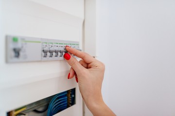 Woman switching off electric fuse