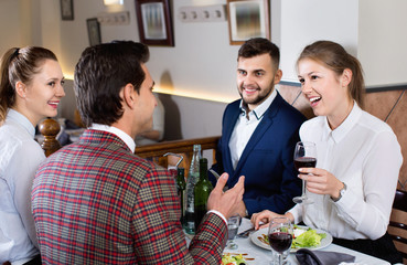 Friendly meeting over dinner with wine in restaurant