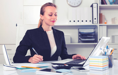 businesswoman in suit filling up documents