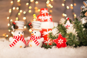 Christmas decoration on a wooden background with snowman, snow and  lights