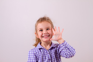 Cute little girl happily shows an open hand