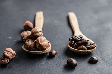Hazelnuts and coffee beans on wooden spoons, close up