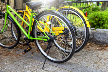 Fototapeta na wymiar Row of parked bicycles on sidewalk in public park